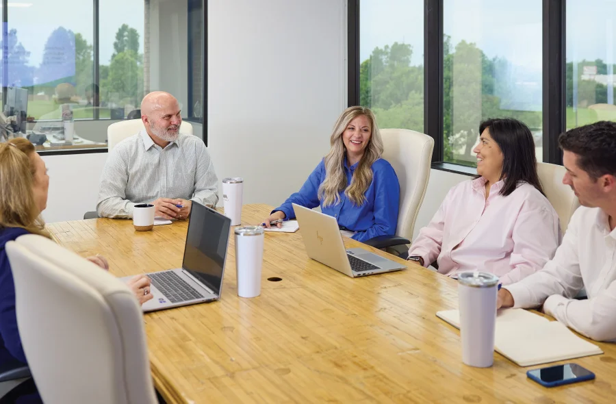 team gathered for a meeting, all members smiling